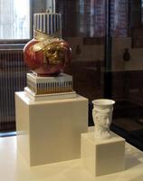 Red urn with animal face and blue/gold decoration