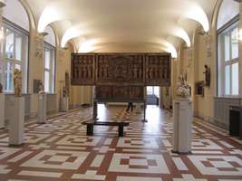 Large wooden religious triptych; floor has brown rectangular tile pattern