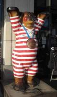Painted bear in red and white gym suit, wearing medal around neck