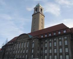 Three-story brick building with large clock tower
