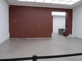 Room with partially painted walls and push broom in corner