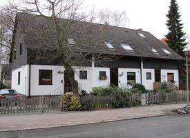 Three adjoining houses; white walls, gray roof