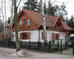 white house with brown wood upper floor and roof