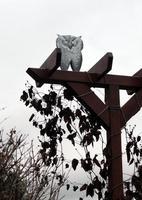 Metal owl atop wooden clothesline support
