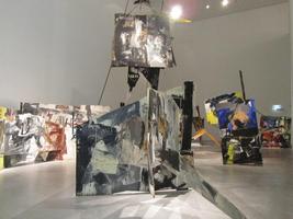 abstract paintings at all angles on floor and hanging from ceiling