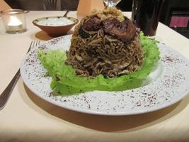 “Hill” of rice and vegetables on lettuce; chicken breast slices are within.