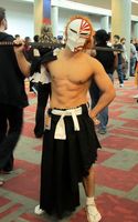 Warrior wearing white “skull mask” with red decorations and carrying a Japanese style sword