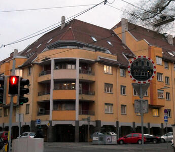 Yellow four-story building with rounded facade