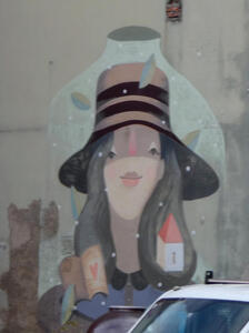 Wall painting of woman with long hair in broad-brimmed hat