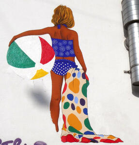 woman with beach ball and polka dotted beach towel
