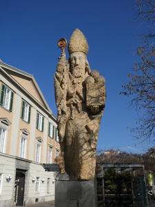 front of statue of bishop with staff holding tablet
