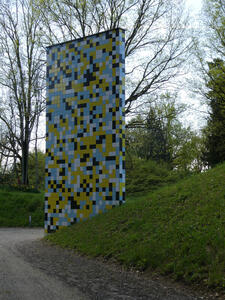 Large rectangular column with colored tiles in white, dark blue, light blue, and yellow