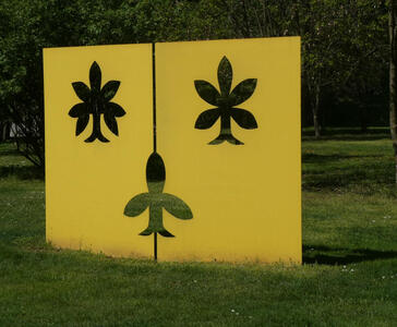 yellow metal sculpture with cutout leaves