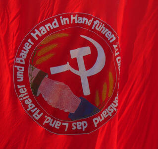 Flag with hammer and sickle. Arbeiter und Bauer Hand in Hand fürhen zu ...ohlstand das Land.