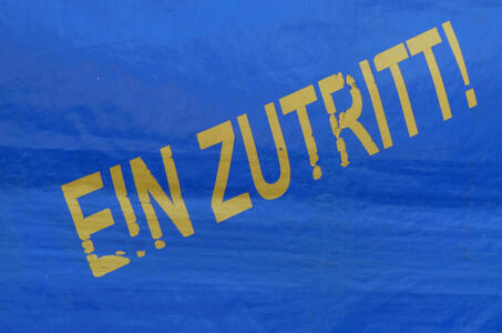 Bue tarp with yellow lettering: EIN ZUTRITT!