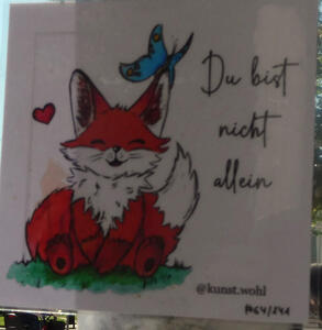 Drawing of a cartoon fox with a blue butterfly sitting on the fox's ear. Text: Du bist nicht allein