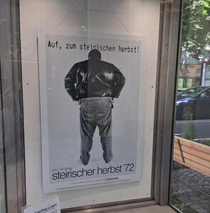 Man in leather jacket and jeans, facing away from camera. Auf, zum steirischen herbst!