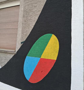 Circle with four quadrants in green, yellow, red, and blue on a black background