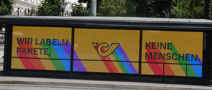 Wir labeln Pakete, keine Menschen.  Austrian postal service logo in middle; letters have rainbow background.