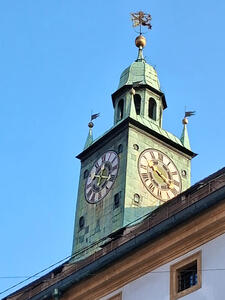 Green clock tower with weather vane on top