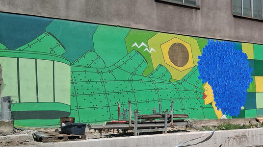Mural showing Kunsthaus and a woman with blue hair.