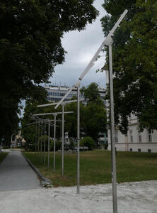 Row of vertical poles. At top of each pole is a crossbar. The crossbars are all at different angles.