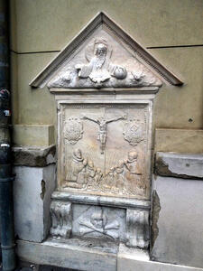 People praying to a crucified Christ. At bottom of carving is a skull and crossbones.