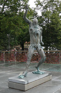 Abstract sculpture of person with one arm raised above head