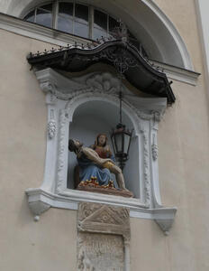 A Pieta sculpture in a niche on a wall
