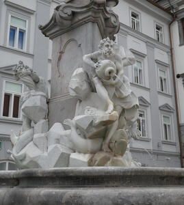 Water-pourer sculpture at base of fountain