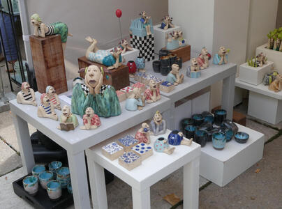 Figurines of people with their arms and hands on their faces.