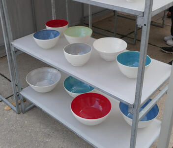 white bowls with blue, red, green, and gray interiors