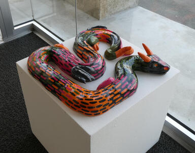 Orange, red, black, and green serpent with orange horns