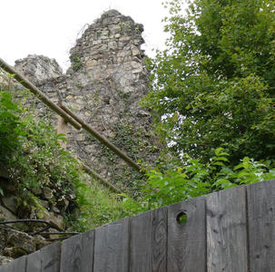 Broken-down walls in background; fence in foreground