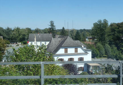 White houses with gray roofs in background; wooden fence in foreground