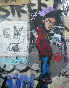 Glowering man in red hoodie and purple baseball cap, hand in pockets.