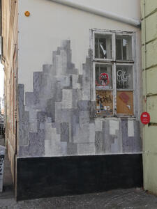 Wall painted with various sizes of rectangles in varying shades of gray.