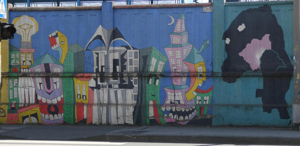 At left, a cartoonish cityscape where buildings have teeth. At right, a blobby looking character somewhat resembling a whale.