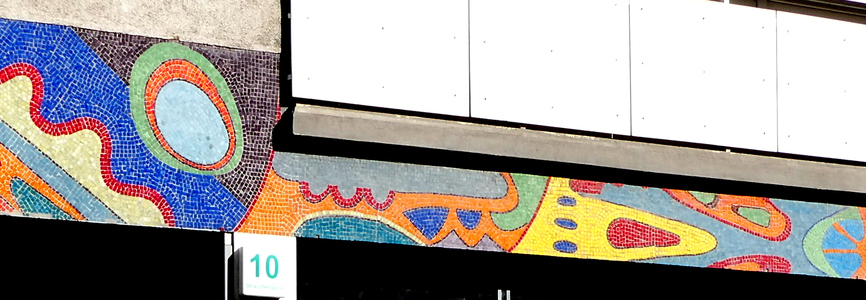 Mosaic with abstract geometric shapes in multiple colors (red, white, orange, yellow, blue, and green)