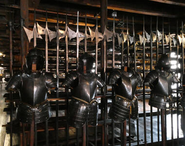 Suits of armor in front, battle axes in background