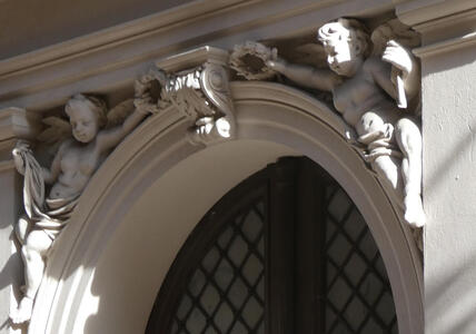 Carved cherubs above an arch over a window