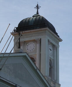 Clock tower. One of the clocks has the hands missing.