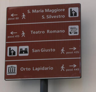 Sign showing directions and number of steps to tourist attractions