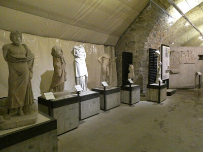 Room with multiple statues, most of which are headless