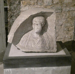 Badly weathered bust of a man carved into a hemispherical opening.