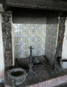 Interior of a fireplace lined with ceramic tiles that have geometric design on them
