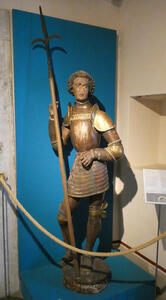 Wooden statue of man in armor holding a spear