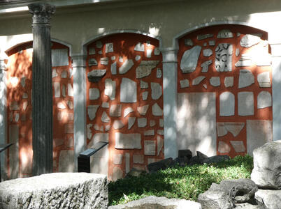 Ochre-painted wall with shards of stone attached