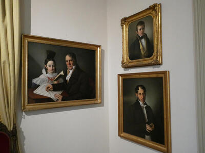 Oil paintings of a man and a young woman, a young boy, and a man wearing glasses