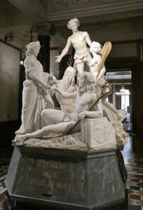 Statue of the cutting of the isthmus of Suez. A young man is near the top; a bearded man and another younger man are seated. Women are at their side.